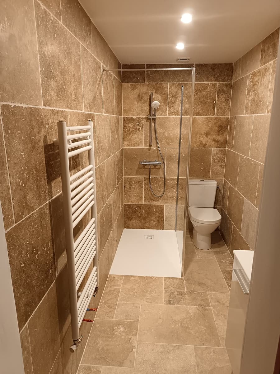 Salle de bain habillée en carrelage et faïence effet travertin par FTC Carrelage Maçonnerie