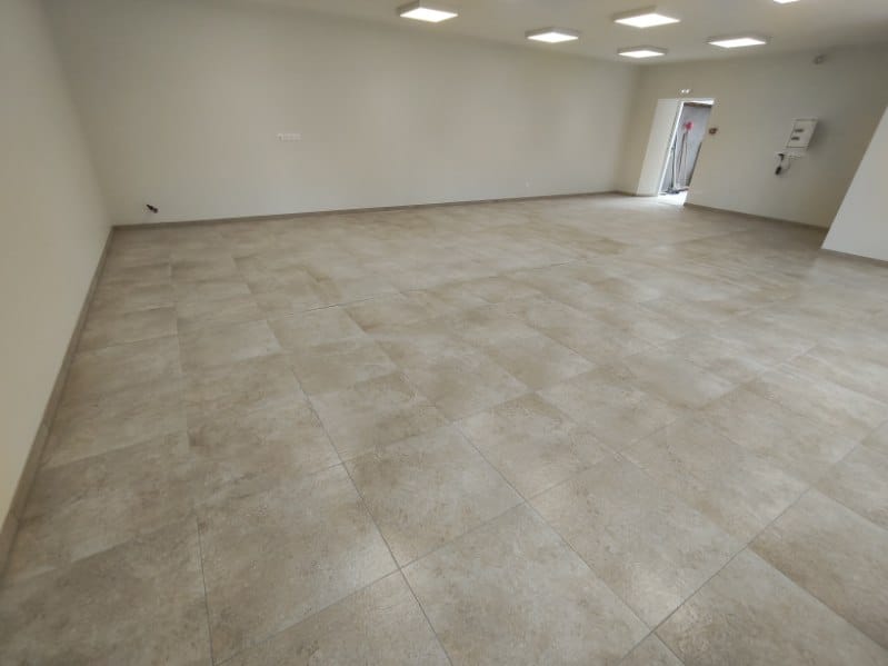 Grande salle après pose de carrelage grand format effet pierre par FTC