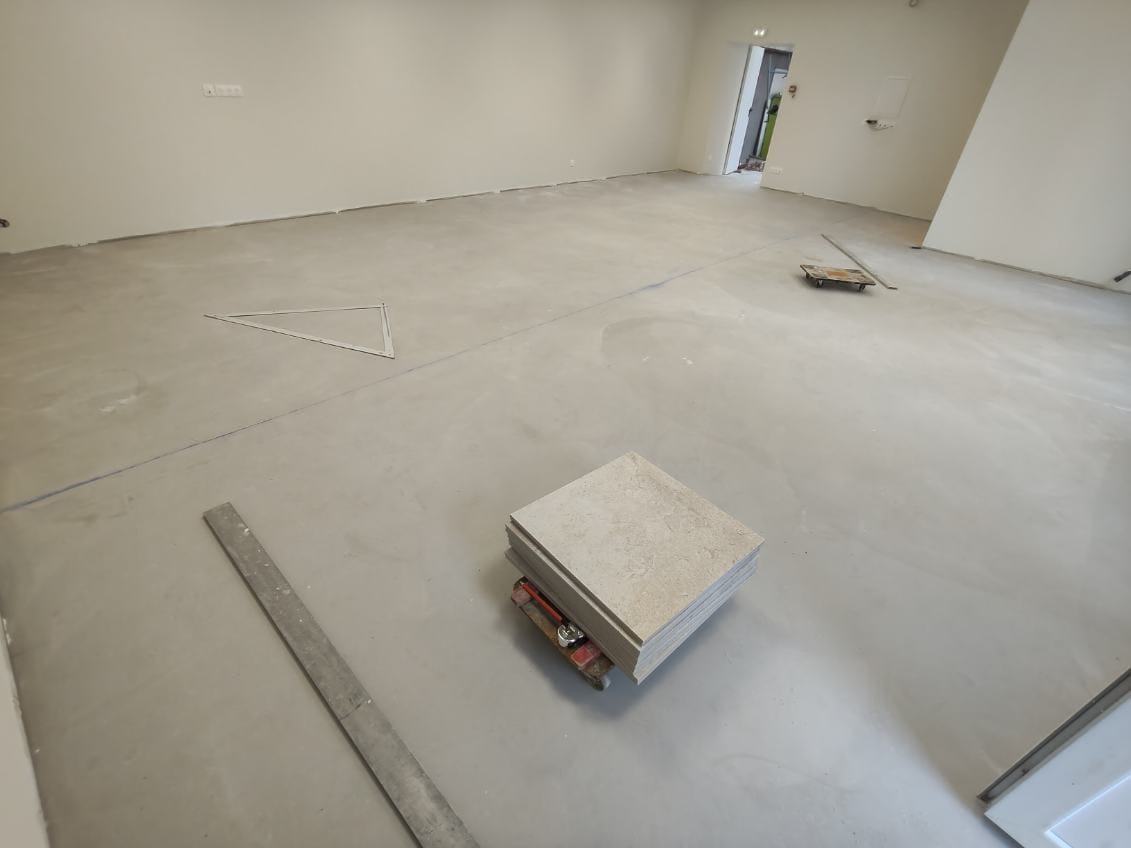 Grande salle avant carrelage : chape prête à recevoir le carrelage grand format