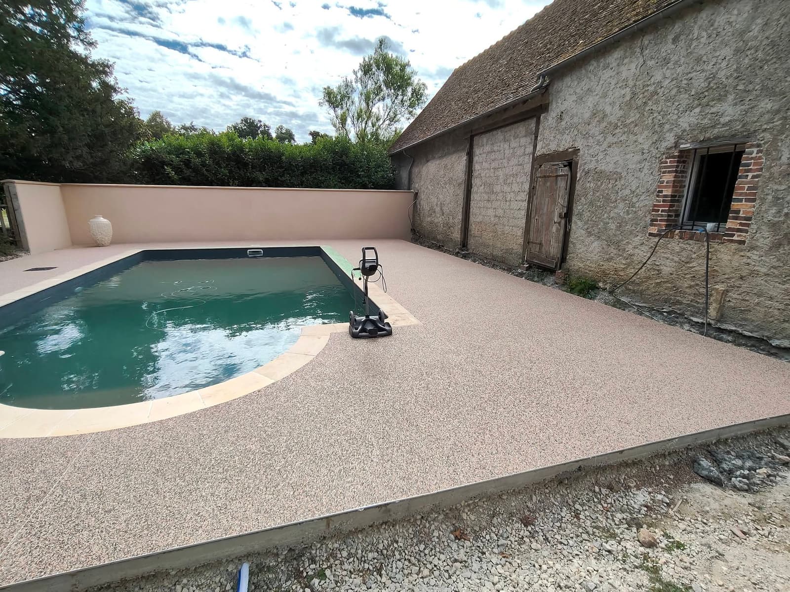Plage de piscine en moquette de pierre beige posée par FTC Carrelage Maçonnerie aux Villages Vovéens en Eure-et-Loir