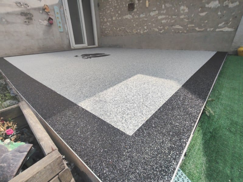 Terrasse en moquette de pierre bicolore avec bordure noire réalisée par FTC