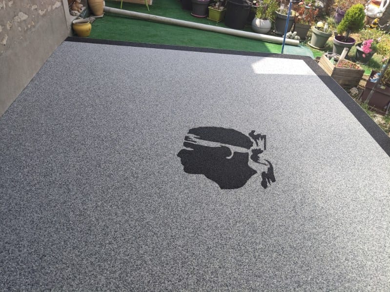 Terrasse en moquette de pierre avec tête de Maure corse intégrée, réalisée par FTC en Eure-et-Loir